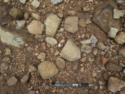ก้อนหินวัตถุดิบและหินที่มีร่องรอยการกะเทาะที่พบบนผิวถนนทางขึ้นสู่ศูนย์ข้อมูลฯ<br>